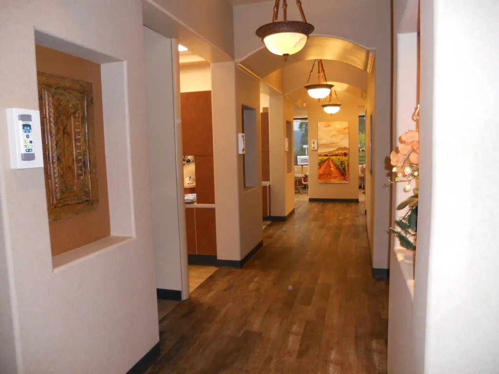 Hallway to operatory rooms with flowers, a photo and a painting